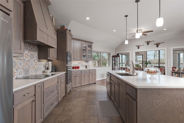 kitchen with light countertops, an island with sink, appliances with stainless steel finishes, and a sink