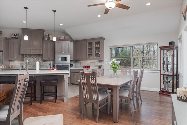 dining room featuring recessed lighting, light wood-type flooring, a ceiling fan, and vaulted ceiling