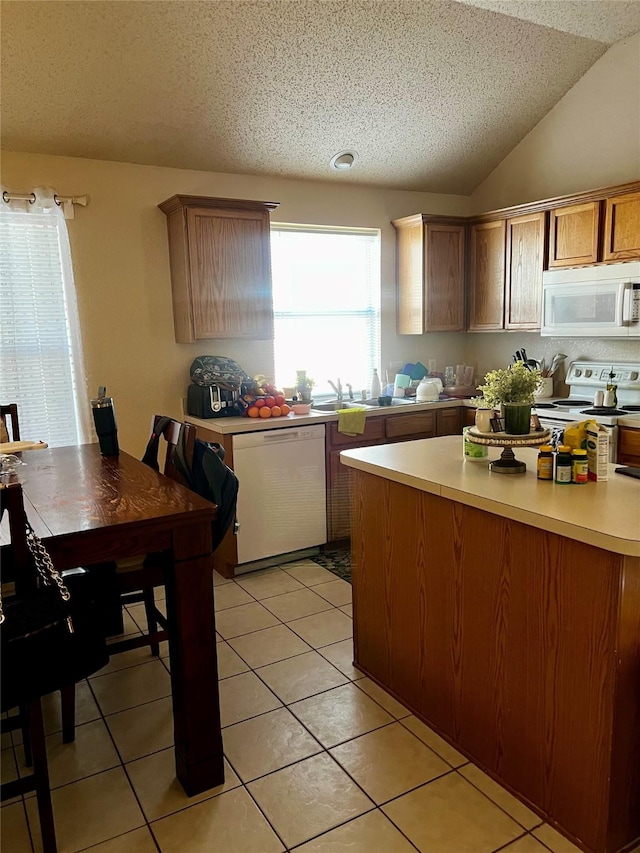 kitchen featuring a textured ceiling, white appliances, light countertops, light tile patterned floors, and lofted ceiling