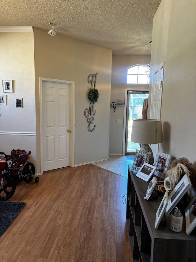 entrance foyer with wood finished floors, baseboards, and a textured ceiling