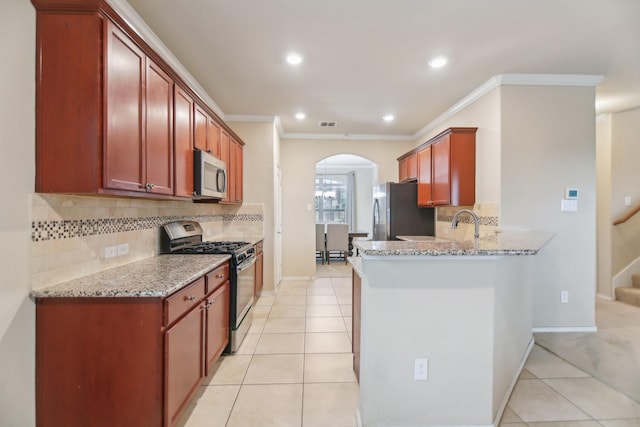 kitchen featuring light tile patterned flooring, light stone countertops, arched walkways, and stainless steel appliances