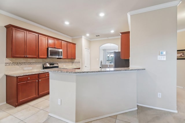 kitchen with light stone counters, arched walkways, stainless steel appliances, decorative backsplash, and crown molding