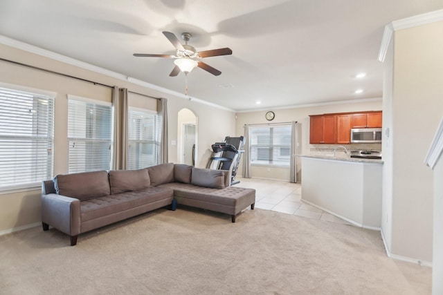 living room featuring a ceiling fan, light tile patterned flooring, arched walkways, light carpet, and crown molding