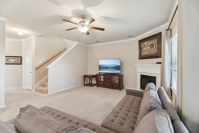 living room featuring visible vents, light carpet, a fireplace with raised hearth, stairway, and crown molding