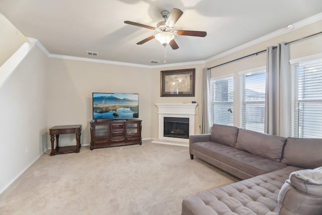 living area with visible vents, light carpet, a fireplace with raised hearth, ornamental molding, and a ceiling fan