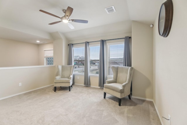 sitting room with visible vents, light colored carpet, a ceiling fan, and baseboards