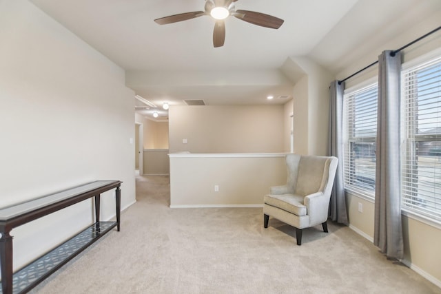 living area with a ceiling fan, baseboards, visible vents, and light carpet