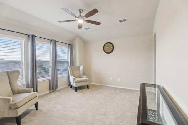 living area with light carpet, visible vents, baseboards, and lofted ceiling