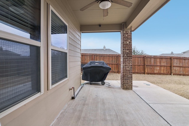 view of patio with area for grilling, a ceiling fan, and a fenced backyard