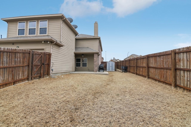 rear view of house with a patio area, an outbuilding, a storage shed, and a fenced backyard