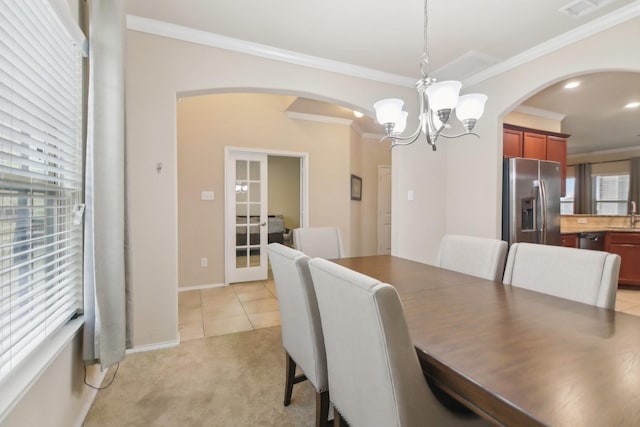 dining room featuring a notable chandelier, arched walkways, a wealth of natural light, and ornamental molding