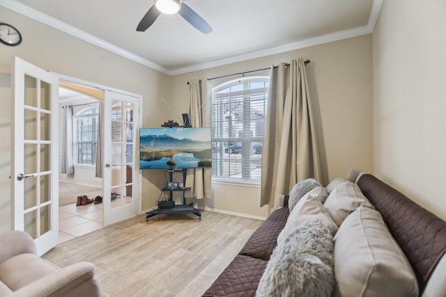 sitting room featuring wood finished floors, french doors, crown molding, baseboards, and ceiling fan