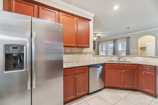 kitchen featuring a sink, stainless steel appliances, tasteful backsplash, and light tile patterned floors