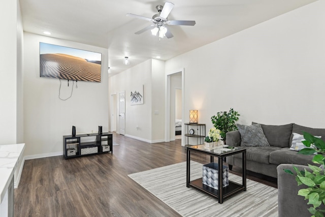 living area featuring baseboards, ceiling fan, and wood finished floors