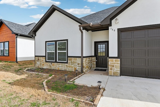 view of front of house featuring an attached garage, stone siding, roof with shingles, and stucco siding