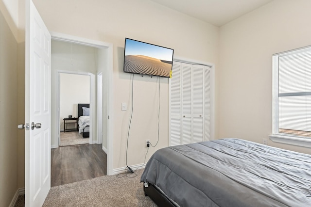 carpeted bedroom featuring baseboards and a closet