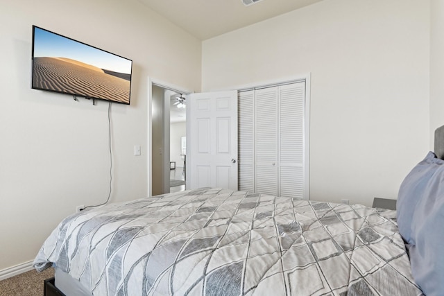 carpeted bedroom with a closet and baseboards