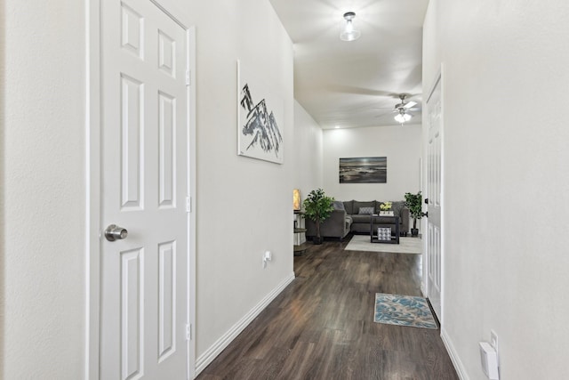 corridor with baseboards and dark wood finished floors