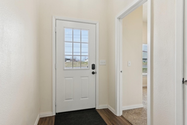 doorway with baseboards and dark wood-style floors