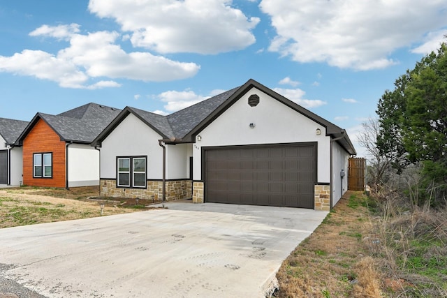 view of front facade with an attached garage, stone siding, driveway, and stucco siding