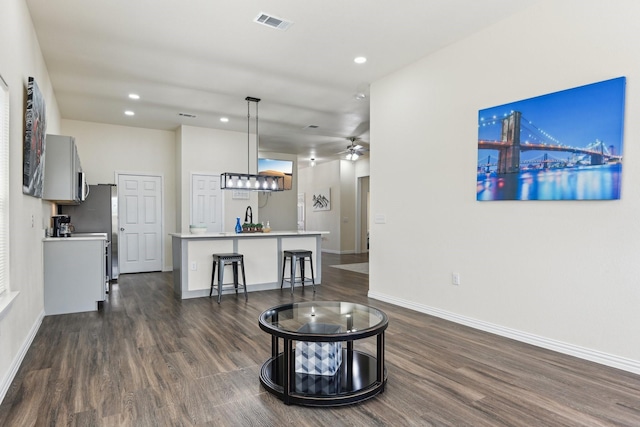 living room featuring dark wood-type flooring, recessed lighting, baseboards, and visible vents