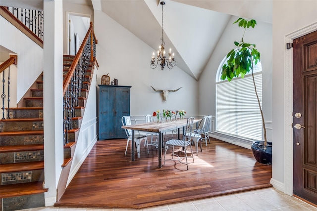 dining space with a chandelier, wood finished floors, and stairs