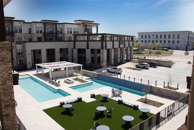 community pool featuring a jacuzzi, a patio area, and fence