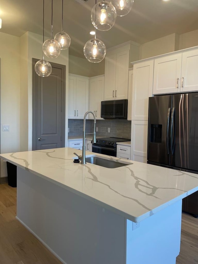 kitchen featuring tasteful backsplash, light wood-style floors, stainless steel refrigerator with ice dispenser, white cabinetry, and a sink