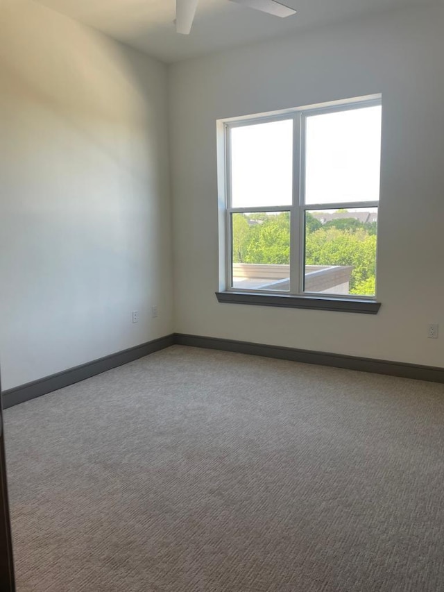 spare room with baseboards, carpet floors, and a ceiling fan