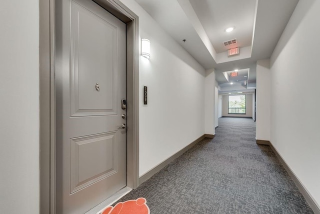 hallway with visible vents, carpet floors, and baseboards