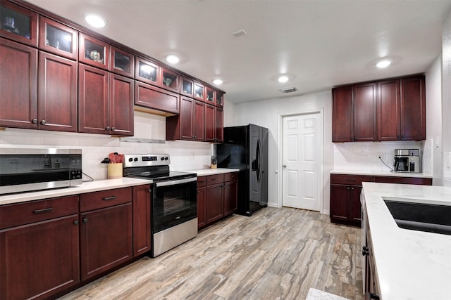 kitchen with stainless steel appliances, light wood finished floors, visible vents, and light countertops