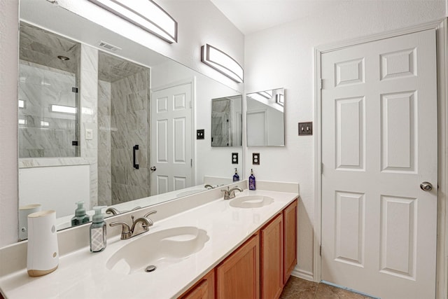 full bathroom featuring double vanity, visible vents, a marble finish shower, and a sink