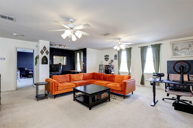 living room with visible vents, light carpet, and a ceiling fan