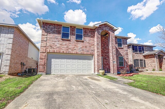 traditional-style home featuring a front yard, an attached garage, concrete driveway, central air condition unit, and brick siding