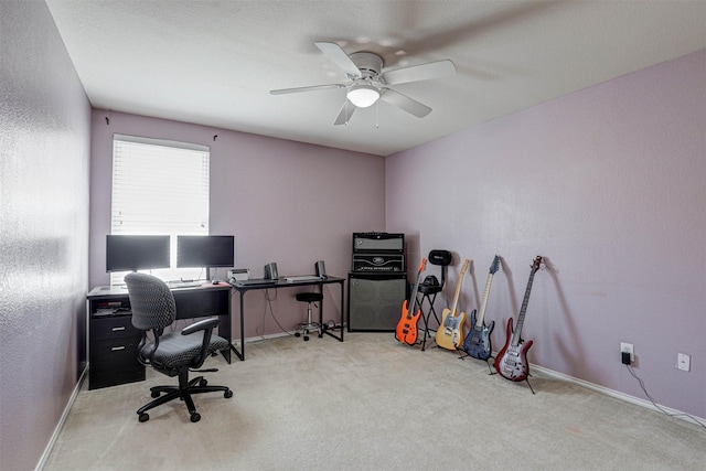 carpeted office featuring ceiling fan, baseboards, and a textured wall