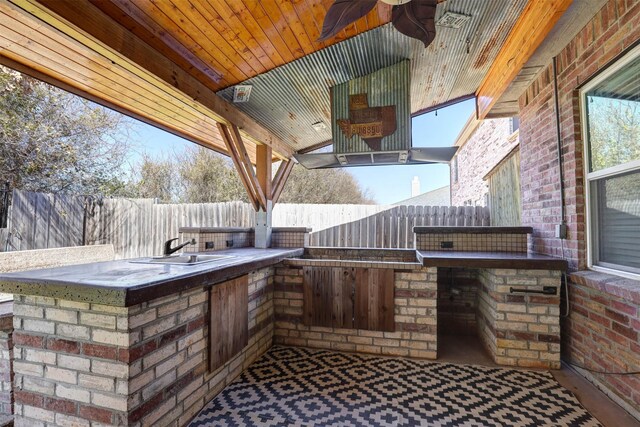 view of patio featuring area for grilling, fence, and a sink