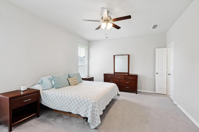 bedroom with visible vents, light colored carpet, baseboards, and ceiling fan