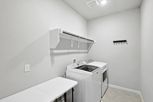 laundry area with laundry area, baseboards, visible vents, and washer and clothes dryer