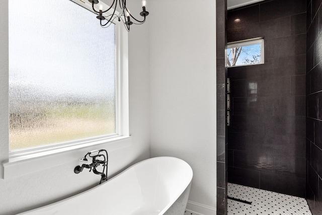 full bath featuring a freestanding tub, tiled shower, and a notable chandelier