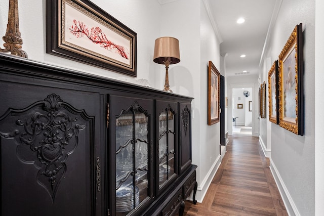 hallway with visible vents, ornamental molding, dark wood finished floors, recessed lighting, and baseboards