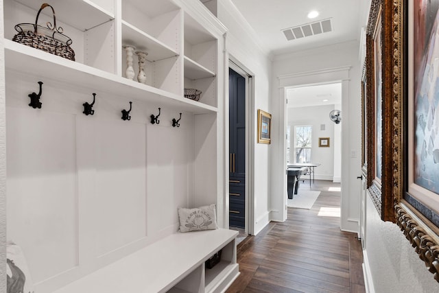 mudroom featuring visible vents, baseboards, dark wood finished floors, and ornamental molding