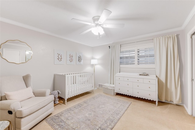 bedroom with a crib, a ceiling fan, light carpet, and crown molding