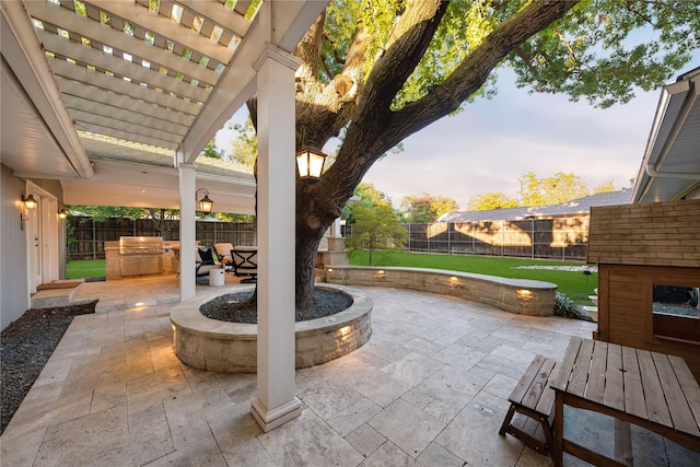 view of patio featuring a pergola, exterior kitchen, and a fenced backyard