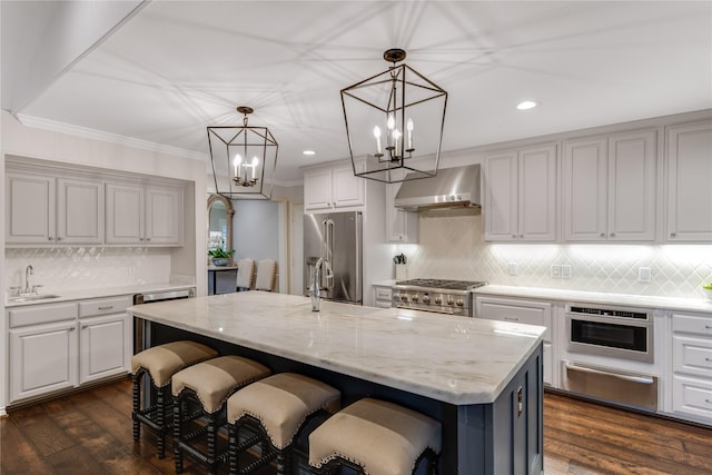 kitchen featuring dark wood-style floors, a sink, extractor fan, a warming drawer, and high quality appliances