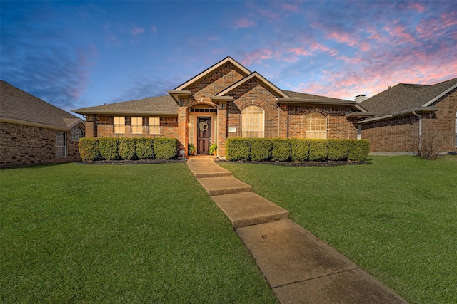 single story home featuring brick siding, a shingled roof, and a front yard