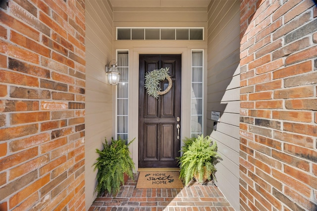 entrance to property featuring brick siding