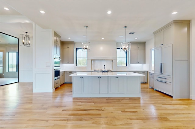 2005 Meadowlark Ct, Aledo, TX 76008 - kitchen with a chandelier, light countertops, light wood finished floors, a kitchen island with sink, and recessed lighting