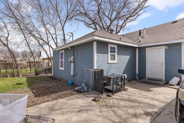 rear view of house featuring fence, roof with shingles, and a patio area