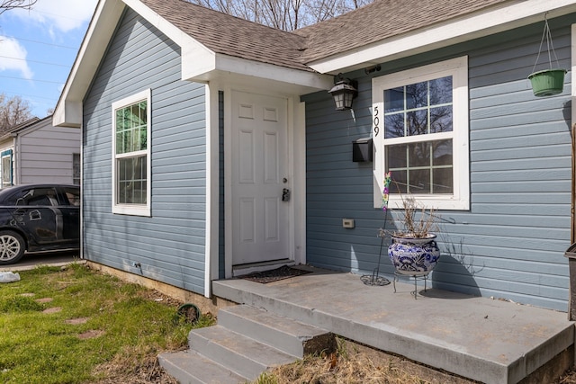 property entrance featuring a shingled roof