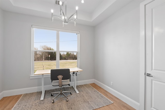 home office featuring visible vents, an inviting chandelier, baseboards, and wood finished floors